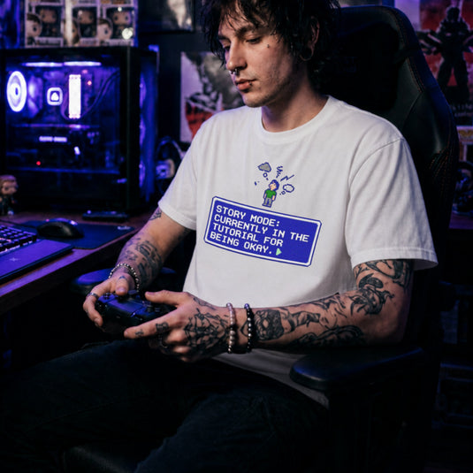 Translation missing: en.White t-shirt with pixel art character, thought cloud, and RPG text box: Story Mode tutorial for being okay