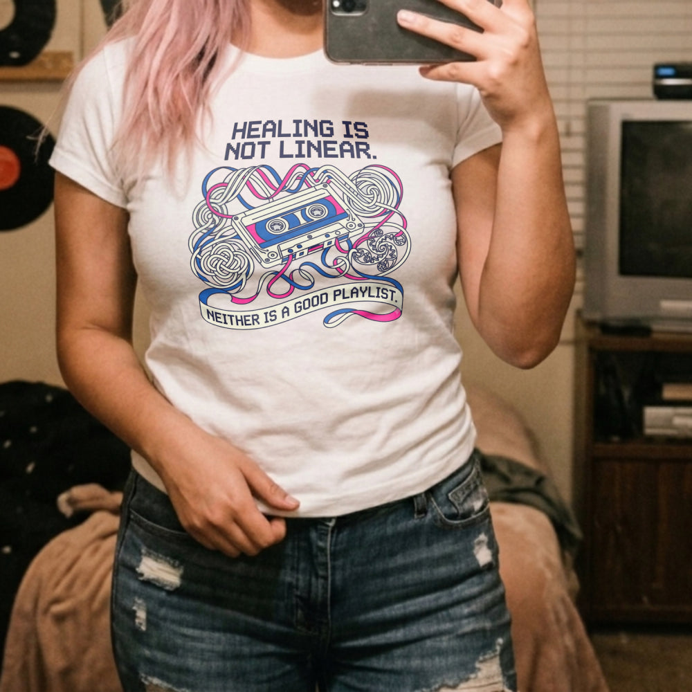 Translation missing: en.Alt n Vibe white women's t-shirt with a retro cassette tape, tangled pink and blue ribbon, and Healing Is Not Linear text